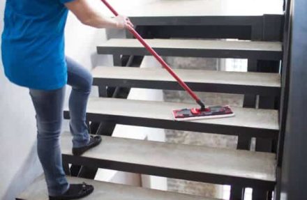 operatrice durante la pulizia delle scale di un condominio