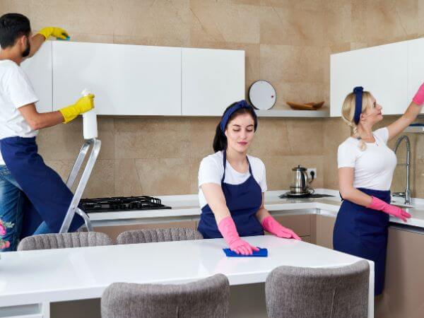 tre operatori durante la pulizia professionale di una cucina di un appartamento