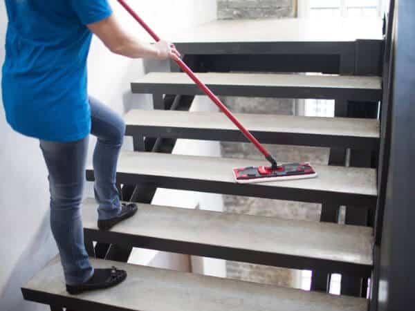 operatrice durante la pulizia delle scale di un condominio